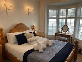 A bedroom with a bed and dresser at Seahorse Cottage in Weymouth
