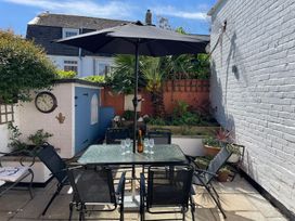 A garden with a table and chairs under an umbrella at Seahorse Cottage Weymouth