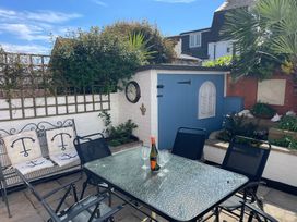 A garden with a table and chairs at Seahorse Cottage in Weymouth