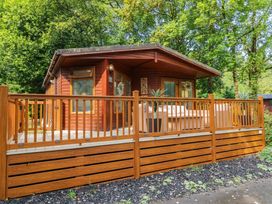 A cabin with a deck and outdoor furniture at Terabitha Lodge Troutbeck