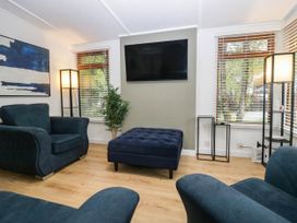 A living room with a sofa and ottoman at Terabitha Lodge in Troutbeck