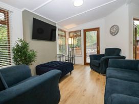 A living room with furniture and a television at Terabitha Lodge in Troutbeck