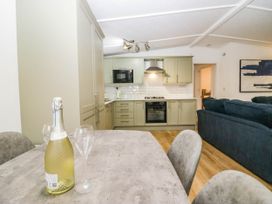 A kitchen with a table and champagne at Terabitha Lodge in Troutbeck
