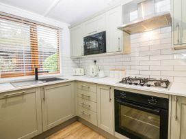 A kitchen with a sink, stove, microwave, and kettle at Terabitha Lodge in Troutbeck