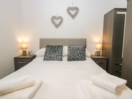 A bedroom with a bed and bedside lamps at Terabitha Lodge in Troutbeck