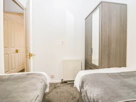 A bedroom with two beds and a wardrobe at Terabitha Lodge in Troutbeck