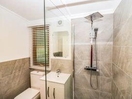 A bathroom featuring a shower, toilet, sink, and window at Terabitha Lodge in Troutbeck