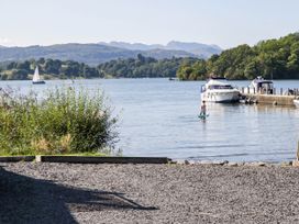 A lake scene with boats and a person on a paddle board at Terabitha Lodge Troutbeck