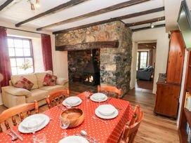 A dining room with a table and chairs near a fireplace at Ty Fferm in Newport