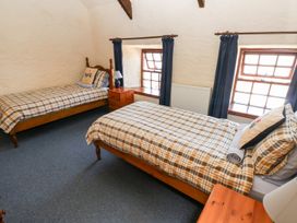 A bedroom with two single beds and windows at Ty Fferm Newport