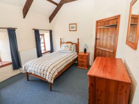 A bedroom with a single bed and wooden furniture at Ty Fferm in Newport
