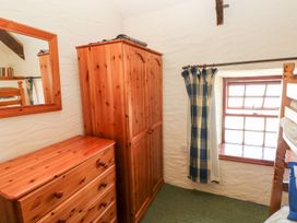 A bedroom with a wardrobe, chest of drawers, and a window at Ty Fferm in Newport