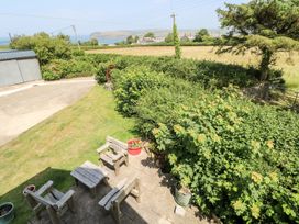 A garden with seating and a view of the sea at Ty Fferm in Newport
