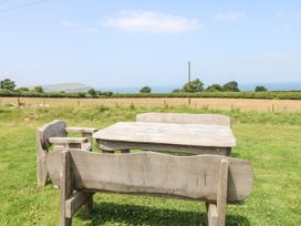 A table and chairs in an outdoor area overlooking the ocean at Ty Fferm, Newport