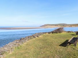 A view of the sea and grass with a bench at Ty Fferm in Newport