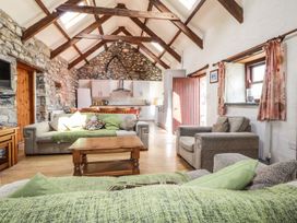 A living room with a sofa and a kitchen area at Ty Felin in Newport
