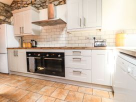 A kitchen with cabinets, oven, toaster, and refrigerator at Ty Felin Newport