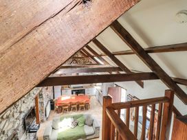 A living room with wooden beams and a dining area at Ty Felin Newport