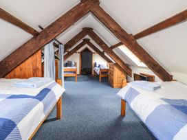 A bedroom with multiple beds and a dresser at Ty Felin Newport