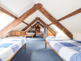 An attic with beds and wooden beams at Ty Felin Newport