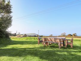 An outdoor seating area with a wooden table and chairs at Ty Felin in Newport