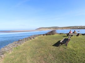 A view of people sitting on a bench near water at Ty Felin in Newport