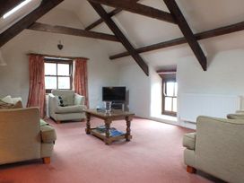 A living room with sofas, a coffee table, and a television at Ty Cariad in Newport