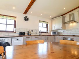 A kitchen with appliances and wooden table at Ty Cariad in Newport