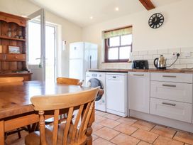 A kitchen with a table, chairs, and appliances at Ty Cariad in Newport