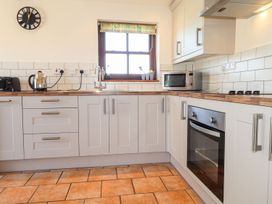 A kitchen with a kettle, microwave, and an oven at Ty Cariad in Newport