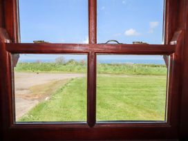 A view from a window showing grass and sea at Ty Cariad Newport