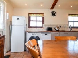 A kitchen with appliances and a dining table at Ty Cariad in Newport