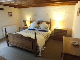 A bedroom with a bed and wooden furniture at Ty Cariad in Newport