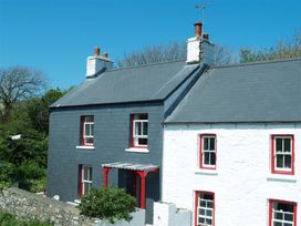 A house with a black and white exterior at Dinas Island Cottage Dinas Cross