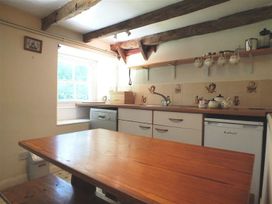 A kitchen with a table and sink at Dinas Island Cottage Dinas Cross