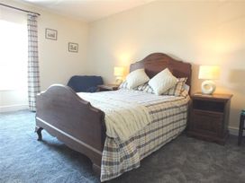 A bedroom with a bed and bedside table at Dinas Island Cottage Dinas Cross