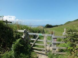 A gate leading to a pathway in an outdoor area at Dinas Island Cottage in Dinas Cross