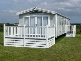 A mobile home with a deck and steps at Morwenna in Hayle