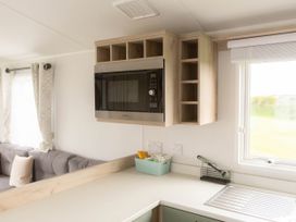 A kitchen with a microwave above the sink at Morwenna in Hayle