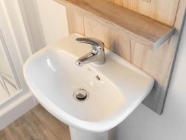 A sink with a tap and wall shelf at Morwenna in Hayle