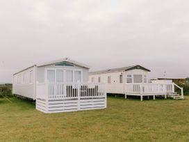 Two mobile homes with decks in an outdoor setting at Morwenna in Hayle