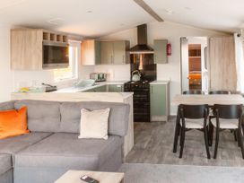 A living room with a sofa and dining area at Lamorna in Hayle
