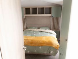 A bedroom with a bed and storage cabinets at Lamorna in Hayle