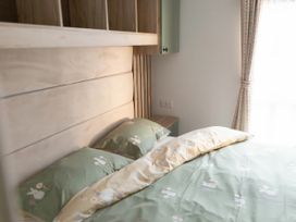 A bedroom with a bed and bedside table at Lamorna in Hayle