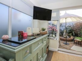 A room with a cabinet and television with outdoor seating at The Summerhouse in Llandudno