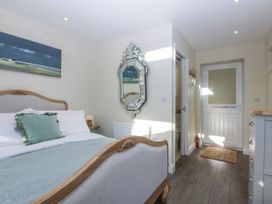 A bedroom with a bed and a mirror at The Summerhouse in Llandudno