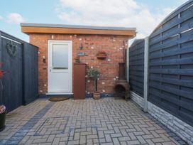 A garden area with a door, planter, and chiminea at The Summerhouse in Llandudno