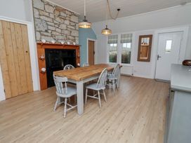 A dining room with a wooden table and chairs at Braeburn in Bamburgh