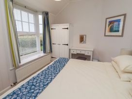 A bedroom with a bed and wardrobe at Braeburn in Bamburgh