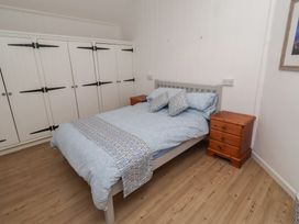 A bedroom with a bed and wardrobes at Braeburn Bamburgh